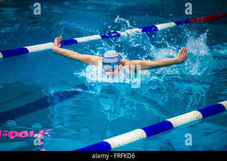 Giovane atleta nuotatore butterfly nella sprint in piscina durante il nuoto internazionale torneo Foto Stock