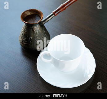 Macchina per il caffè con caffè e la tazza bianca sul tavolo Foto Stock