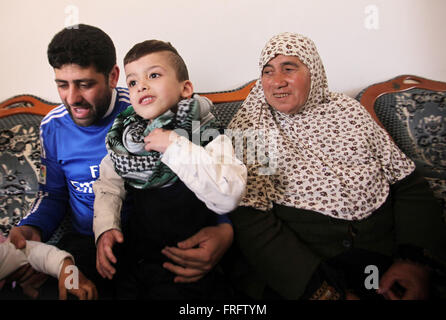 Nablus, West Bank, Territorio palestinese. 22 Mar, 2016. Ragazzo palestinese Ahmed Dawabsha, 5, che hanno subito gravi ustioni in un incendio doloso da sospetti Jewish gli utenti malintenzionati sulla sua casa di famiglia lo scorso luglio e in cui il suo fratello più giovane, Ali, e i suoi genitori morirono entrambi, è accolto da parenti dopo il ritorno dalla Spagna dove ha incontrato il Real Madrid stelle, a suo nonno in casa la Cisgiordania villaggio di Duma vicino a Nablus Marzo 22, 2016. Ahmed Dawabsha suo zio e i suoi nonni tornò in Spagna dove hanno incontrato i giocatori della squadra di calcio spagnola (credito Immagine: © Nedal Eshtayah/immagini APA vi Foto Stock