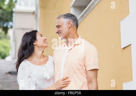 Coppia in cerca di ogni altro mentre in piedi contro la costruzione di Foto Stock