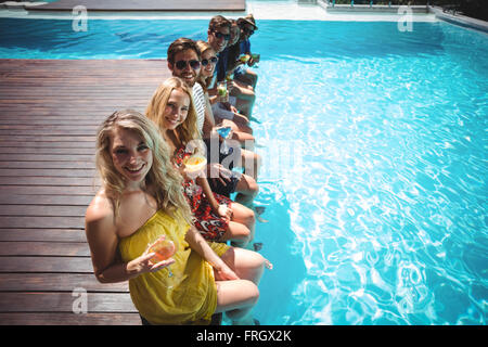 Happy amici seduti in piscina Foto Stock