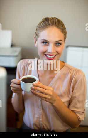 Ritratto di sorridere imprenditrice azienda tazza da caffè Foto Stock