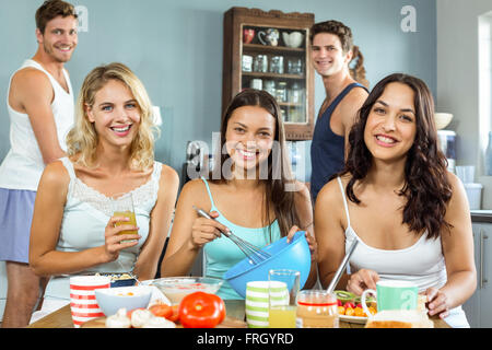 Felice maschio e femmina amici cucina insieme in cucina Foto Stock