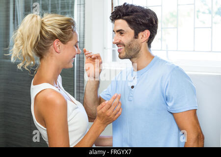 Giocoso uomo l'applicazione di crema sulla donna del naso Foto Stock