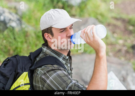 Angolo di Alta Vista del giovane uomo di bere dalla bottiglia Foto Stock