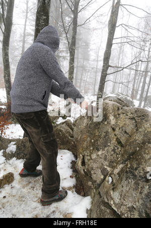 Valoroso cavaliere anonimo rimuove l'Excalibur magica spada nella roccia Foto Stock