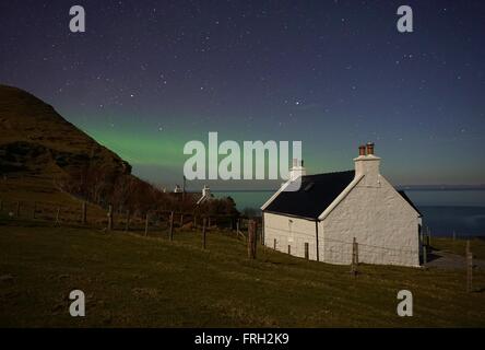 Luci del Nord al di là di un bianco cottage Foto Stock