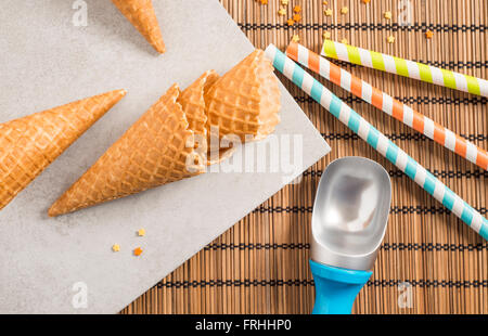 Zucchero colorato spruzzino, cannucce e coni gelato. Preparazione per la festa. Concetto di cibo per lo styling. Foto Stock