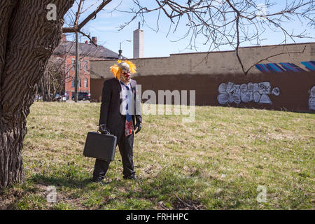 Detroit, Michigan - un uomo vestito come un clown squilibrate sorge in un lotto vacante lungo il percorso delle Marche du Nain Rouge. Foto Stock