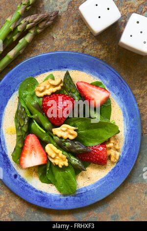 Fragole fresche, asparagi verdi, baby spinaci e insalata di noci servita su piastra Foto Stock