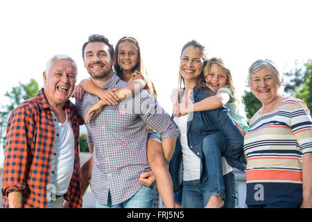 Genitori felici che trasportano le ragazze con i nonni in back yard Foto Stock