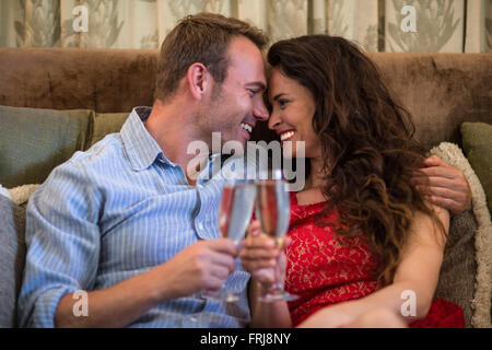 Coppia felice di tostatura flauti champagne Foto Stock