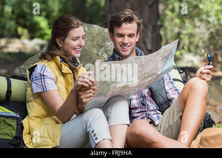 Coppia giovane guardando alla mappa durante la seduta sul campo Foto Stock