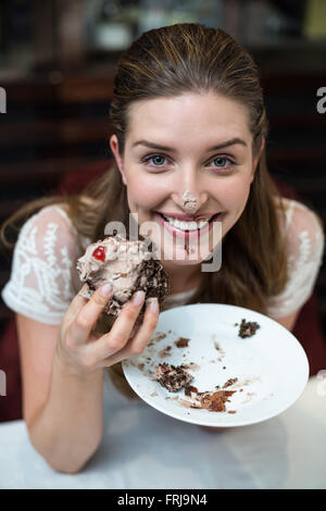 Angolo alto ritratto di donna felice godendo di torta Foto Stock