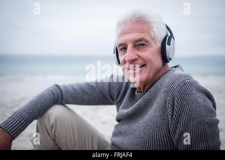 Senior uomo ascoltare musica in cuffia Foto Stock