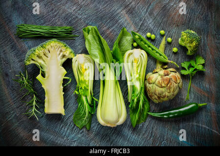 Raccolta di verdure fresche a foglia verde sulla pietra nera Foto Stock