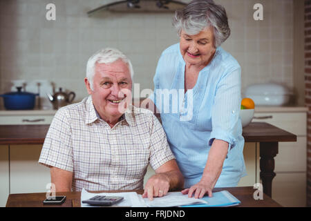 Senior sorridente uomo con la donna mentre il calcolo delle fatture Foto Stock