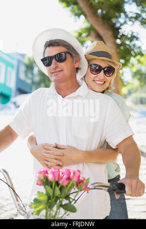 Coppia felice in sella in bicicletta in città Foto Stock