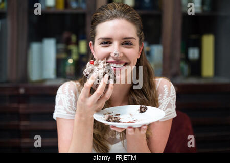 Ritratto di donna felice godendo di torta Foto Stock