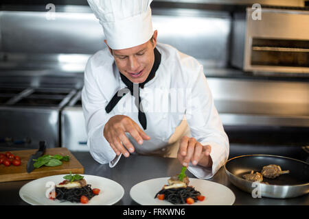 Lo chef prepara il cibo in cucina Foto Stock