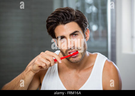 Giovane uomo spazzolatura dei denti Foto Stock