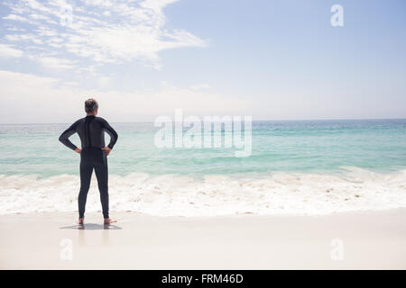 Vista posteriore del senior uomo in piedi con le mani sui fianchi Foto Stock