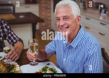 Ritratto di sorridere senior uomo con vino bianco Foto Stock