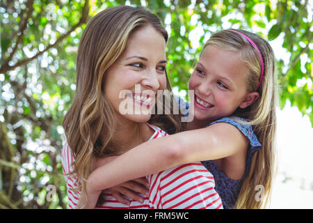 Felice madre dando piggy-back per la figlia Foto Stock