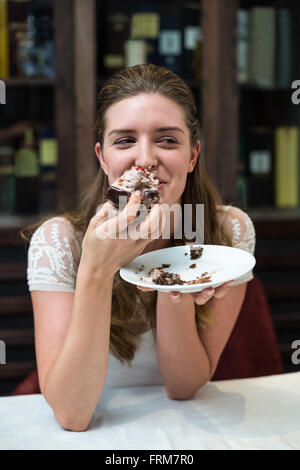 Donna felice godendo di torta Foto Stock