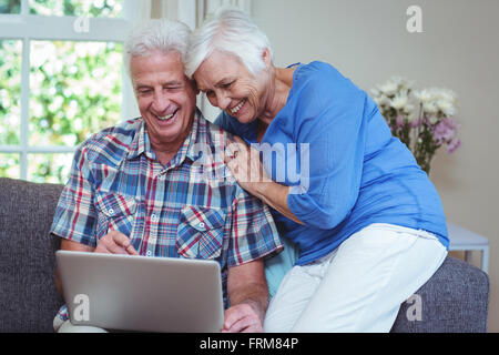 Felice coppia senior utilizzando laptop Foto Stock