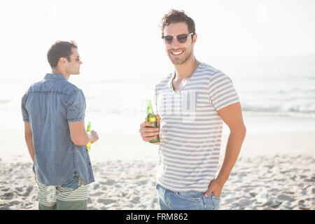 Gli amici a bere una birra sulla spiaggia Foto Stock