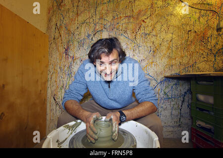 Uomo felice la sagomatura di argilla vaso in ceramica Foto Stock