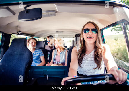 Ragazzi adolescenti e ragazze all'interno di un vecchio camper, roadtrip Foto Stock