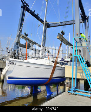 Yacht che viene nuovamente issato in acqua dopo deposito invernale a terra sulla posizione difficile in Premier Chichester marina - Chichester, West Sussex, Regno Unito Foto Stock