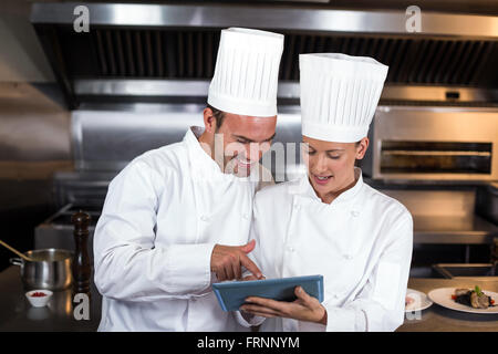 Chef holding negli appunti in cucina Foto Stock
