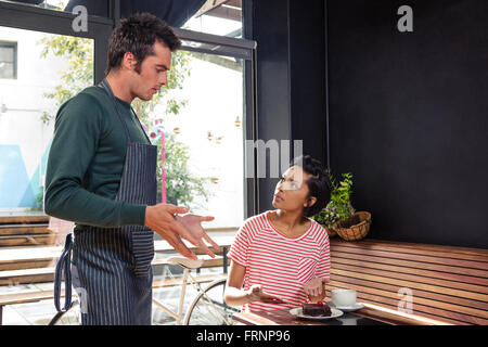 Disaccordo tra un cameriere e un cliente Foto Stock