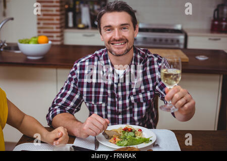 Ritratto di uomo sorridente offerta di vino bianco Foto Stock