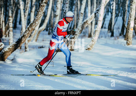 Il vecchio atleta sciatore stile classico in un inverno bosco di betulle, durante il campionato di Chelyabinsk in sci di fondo Foto Stock