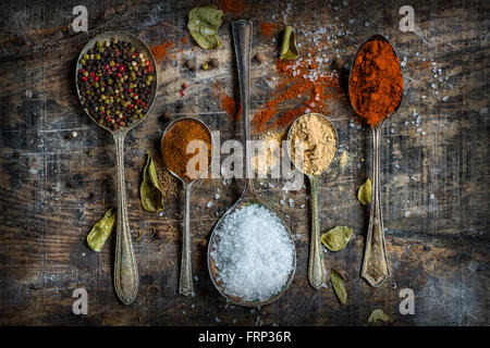 Cucchiai riempito con spezie colorate su tavola in legno rustico - primo piano Foto Stock