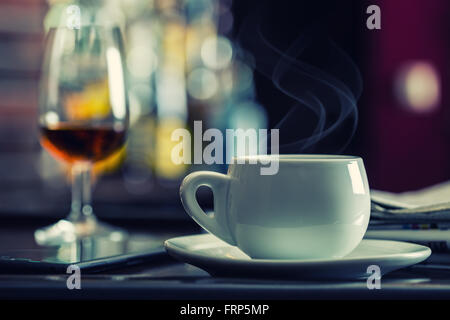 Caffè e drink. Tazza di caffè e brandy Cognac Whiskey aperitivo nel moderno bar notturno Foto Stock