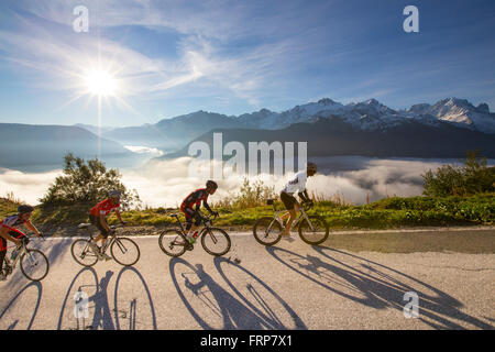 Quattro ciclisti su una tortuosa strada di montagna sul loro modo al serbatoio di Emosson lago delle Alpi sul confine della Francia e Svizzera. Foto Stock