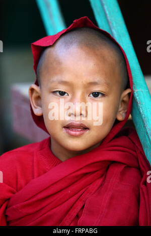 Ritratto di un giovane monaco buddista giocando a un tempio in Amarapura, Mandalay Myanmar (Birmania) Foto Stock