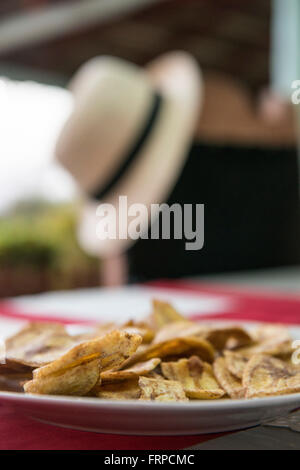 Piastra del chip di piantaggine seduti su un rosso e tovaglie bianche. Trinidad, Cuba Foto Stock