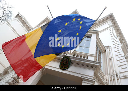 Londra, Regno Unito. 23 Mar, 2016. La bandiera belga (L) e l'Unione europea (UE) bandiera vengono abbassate per metà a piangere le vittime degli attentati terroristici a Bruxelles al di fuori dell'Ambasciata belga nel centro di Londra, Gran Bretagna il 23 marzo 2016. Credito: Han Yan/Xinhua/Alamy Live News Foto Stock