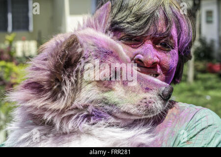 Sivasagar, Assam, India. 24 Mar, 2016. Una donna indiana si applica una polvere colorata per il suo cane durante le celebrazioni della Holi festival nella Sivasagar distretto di nord-est Assam il 24 marzo 2016. Holi il festival di colori, è un rivoltosi celebrazione della venuta di molla e cade il giorno dopo la luna piena ogni anno nel mese di marzo. Festaioli di spruzzatura di polvere colorata e acqua su ogni altro con grande gusto, mentre gli adulti si estendono la mano di pace. Credito: Luit Chaliha/ZUMA filo/Alamy Live News Foto Stock