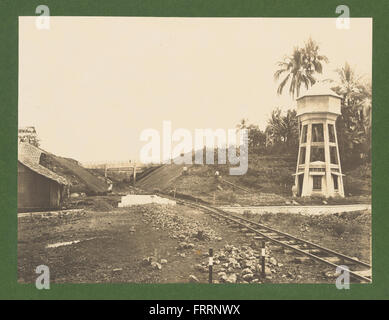 Una fotografia della linea ferroviaria Cirebon-Kroya in costruzione, con la torre dell'acqua essenziale per lo sviluppo ferroviario in corso. Foto Stock