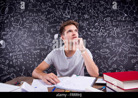 Hipster studente facendo il suo dovere nei confronti di una grande lavagna Foto Stock