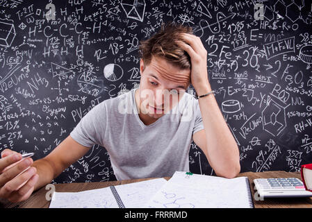 Hipster studente facendo il suo dovere nei confronti di una grande lavagna Foto Stock