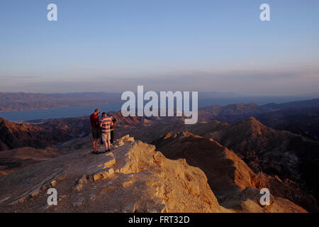 Gli escursionisti in corrispondenza di una piattaforma di osservazione in mount Yoash a Eilat montagne Riserva Naturale nel sud del deserto del Negev in Israele con la vista della punta settentrionale del Mar Rosso, ad est della penisola del Sinai e a ovest dell'Arabia Saudita sulla terraferma. Foto Stock