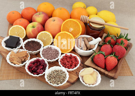 Grande antiossidante alimenti e medicine a base di erbe selezione per raffreddore e influenza rimedio anche alto in vitamina C su un olive wood board. Foto Stock